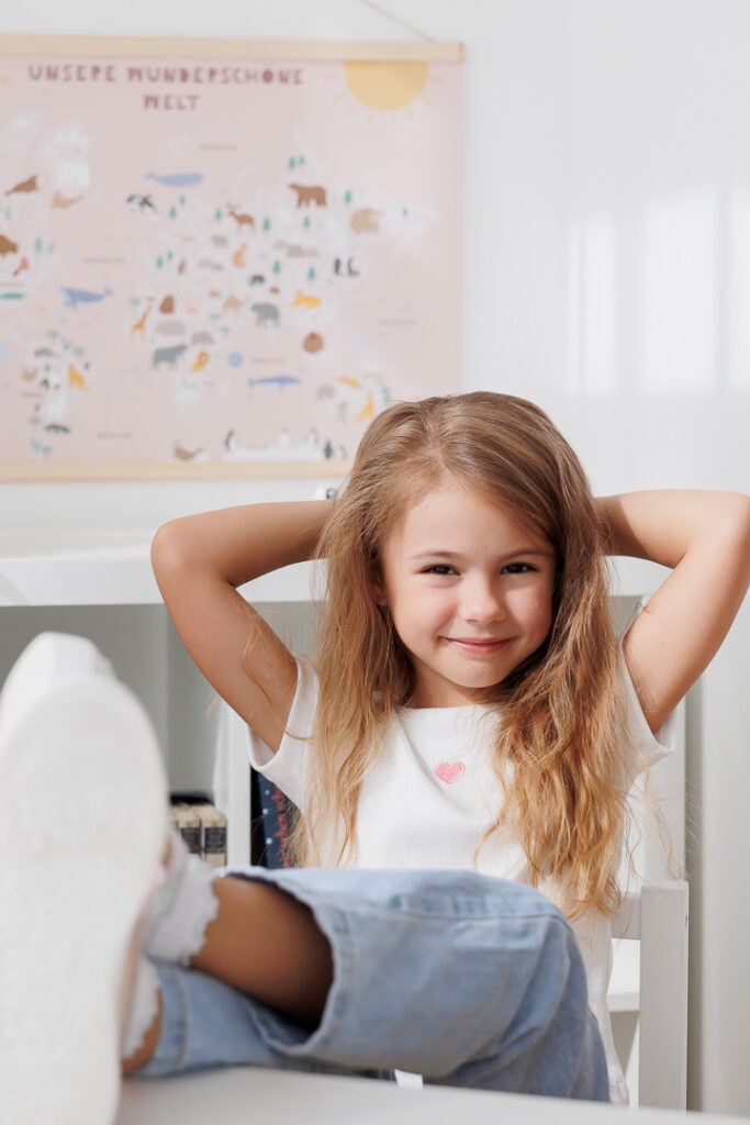 Mädchen verschränkt lächelnd die Hände hinter dem Kopf, Back-to-School-Mini-Session im Fotostudio Atelier 95 in Luxemburg